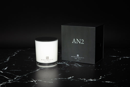 Elegant luxury candle in a glass jar with a clean, minimalist label, softly glowing on a marble surface
